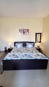 a large bed in a bedroom with two lamps at Radhey Bliss A Cozy Studio Home in Vrindāvan