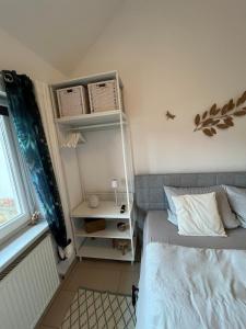 TinyHouse Pfalzperle Auszeit nahe Deutsche Weinstraße & Therme في Ellerstadt: غرفة نوم صغيرة مع سرير وطاولة بجانب السرير +18 صورة