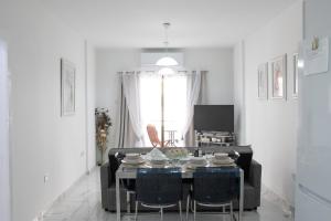 拉纳卡Apartment,NEAR THE BEACH Pinikoudes的带桌子和椅子的白色客厅