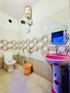 a bathroom with a pink sink and a toilet at Hotel Royal Pinkcity in Jaipur