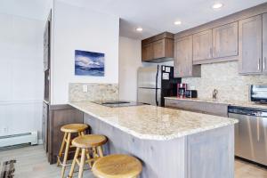 a kitchen with wooden cabinets and a large island with stools at E101 Lake Cliffe condo in Dillon