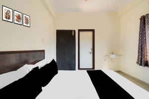 Postel nebo postele na pokoji v ubytování Hotel O Shiridi serinity residency