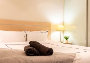 a bed with a towel laying on top of it at Koala Nest Central Adelaide 1BR Apartment with Pool & Sauna - Koala Stay in Adelaide +68 photos