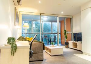 a living room with a couch and a table at Koala Nest Central Adelaide 1BR Apartment with Pool & Sauna - Koala Stay in Adelaide