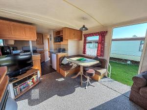 a small kitchen with a table in a caravan at 8 Berth Caravan With Free Wifi At Heacham Holiday Park In Norfolk Ref 21008E in Heacham