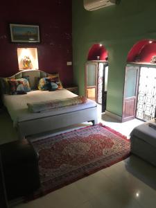 um quarto com uma cama e uma parede vermelha em Shiva Guest House em Varanasi