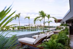 a swimming pool with chaise lounge chairs and palm trees at Luxe Tulum Jacuzzi in Tulum