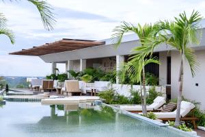 a villa with a swimming pool and palm trees at Luxe Tulum Jacuzzi in Tulum
