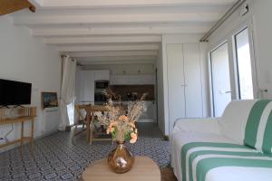 a living room with a vase of flowers on a table at Au petit jardin d'Aizenay in Aizenay