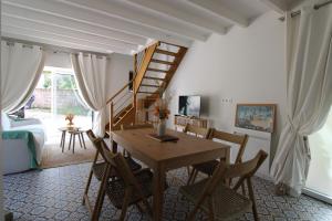 a dining room with a wooden table and chairs at Au petit jardin d'Aizenay in Aizenay