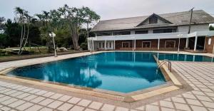 a large blue swimming pool in front of a house at นิวเวิลด์ ระยอง New world Rayong in Rayong