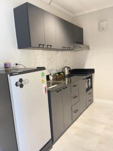 a kitchen with a refrigerator and a sink at นิวเวิลด์ ระยอง New world Rayong in Rayong