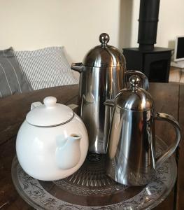 a table with two tea pots and a tea kettle at Stylish small barn near coast private garden Pass the Keys in Saint James