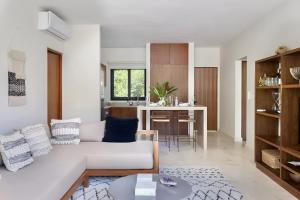 a living room with a white couch and a table at Aldea Zama - Lujo Natural en el Corazón de Tulum in Tulum +22 photos
