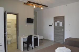 a room with a desk and a bed and a bathroom at Affittacamere Li Manca in Surbo