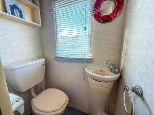 ein kleines Badezimmer mit Toilette und Waschbecken in der Unterkunft Great 6 Berth Caravan With Side Decking In Heacham Ref 21054A in Heacham + 11 Fotos