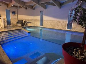 a large swimming pool with blue water at Hôtel Calme Des Pins & Spa in Les Sables-d'Olonne