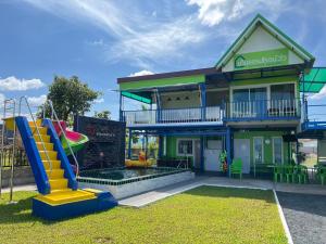 a house with a slide and a playground at Baan Thammarot View in Sirindhorn