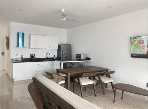a kitchen with a wooden table and chairs and a sink at Oceanfront 2Bed - 2Bath Paradise Mahahual in Mahahual