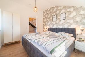 a bedroom with a large bed in a room at FeWo zum kleinen Vogel, Sauna, Landidylle in Apen
