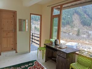 una oficina con escritorio y una gran ventana en Snow View, en Palchān