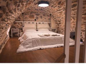 a bedroom with a large bed in a stone wall at Sundays Holiday Apartments in Chios