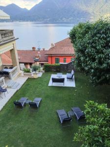 a yard with chairs and a picnic table and a lake at Bed and Breakfast VILLA ARANCIO Ghiffa in Ghiffa