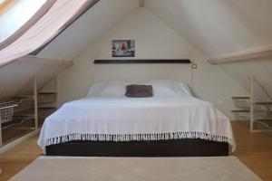 a bedroom with a white bed in a attic at Lepadaloft in Villeneuve-Saint-Georges