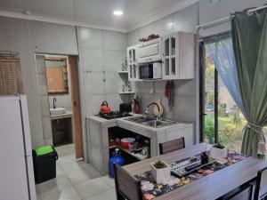 a small kitchen with a sink and a stove at Boskraai Self-Catering -74 Hornbill Street in St Lucia