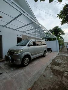 a silver suv parked in front of a building at Kamar Kost AC Luas Tengah Kota in Gombong