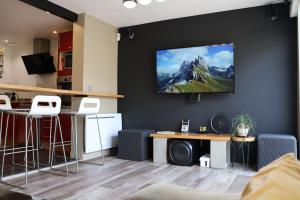 a living room with a tv on a black wall at Lepadaloft in Villeneuve-Saint-Georges