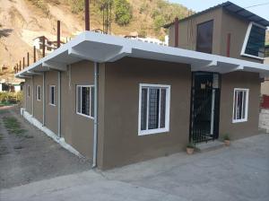 a small brown house with a white roof at Riddhi Siddhi Homestay in Bhīm Tāl