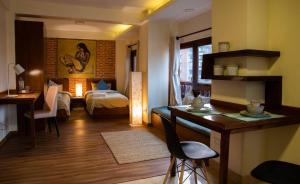 a room with a bedroom with a bed and a desk at Tara Art House Apartment 2 in Pātan
