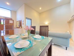 a dining room with a glass table and a couch at BUMI LOKA residence in Gantungan