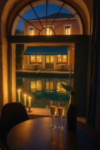 two glasses of wine sitting on a table in front of a window at Piccola Perla sul Canale in Venice