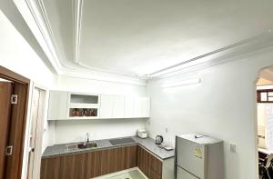 a kitchen with white cabinets and a refrigerator at Hue Harmony Homestay in Thôn Kim Long (1)