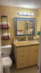 a bathroom with a sink and a toilet and a mirror at Castle beach studio,tennis court and swimming pool with beach access in Miami Beach