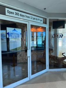 a store front door with a sign that reads open days from to at Castle beach studio,tennis court and swimming pool with beach access in Miami Beach +68 photos