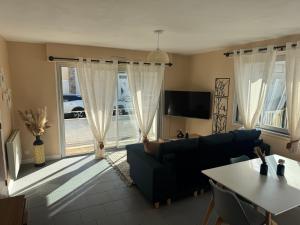 メルリモン・プラージュにあるSUNLIGHT Merlimont Appartement Plage Merlimont 10 mn Berck le Touquetの青いソファとテーブルのあるリビングルーム