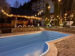 een zwembad voor een gebouw 's nachts bij Rare Forest Retreat & Spa in Bran