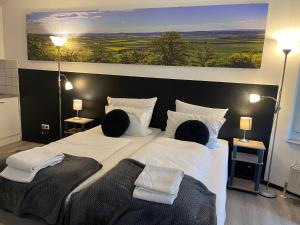 a bedroom with a large bed with two people sitting on it at Ap. Stern in Marburg an der Lahn
