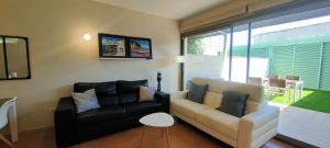 a living room with a couch and a chair at Apartamento Mar&Pol con jardín in Palafrugell