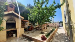 a patio with a tree and a house at GREEN cozy apartment with shared POOL in Split