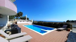a swimming pool sitting on a deck next to a house at GREEN cozy apartment with shared POOL in Split