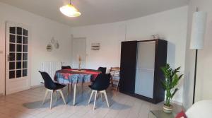 a room with a table and chairs and a refrigerator at Maison cocooning à 6 mn de Honfleur in La Rivière-Saint-Sauveur