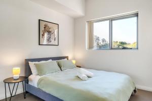 een witte slaapkamer met een groot bed en 2 ramen bij 41B Modern 1 Bedroom Abnb-Style apartment Free Parking in Bankstown
