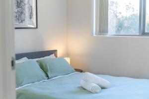 een bed met twee kussens erop in een slaapkamer bij 41B Modern 1 Bedroom Abnb-Style apartment Free Parking in Bankstown
