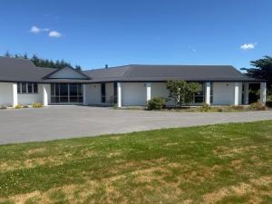 a large white building with a large driveway at Ruataniwha Lodge in Twizel
