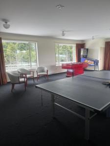 a living room with a ping pong table and chairs at Ruataniwha Lodge in Twizel
