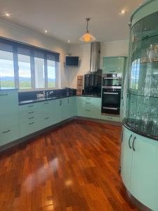 a kitchen with green cabinets and a wooden floor at Ruataniwha Lodge in Twizel